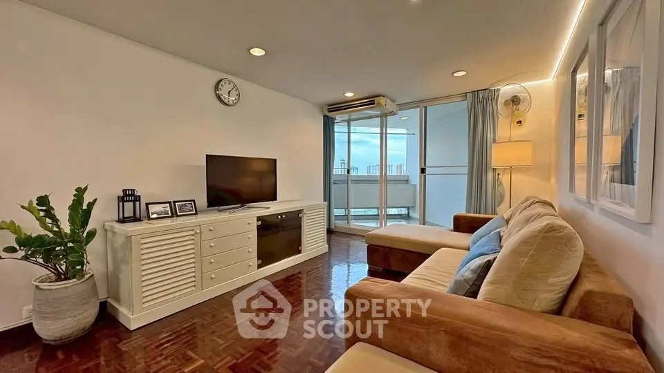 Spacious living room with modern decor and balcony view in urban apartment.