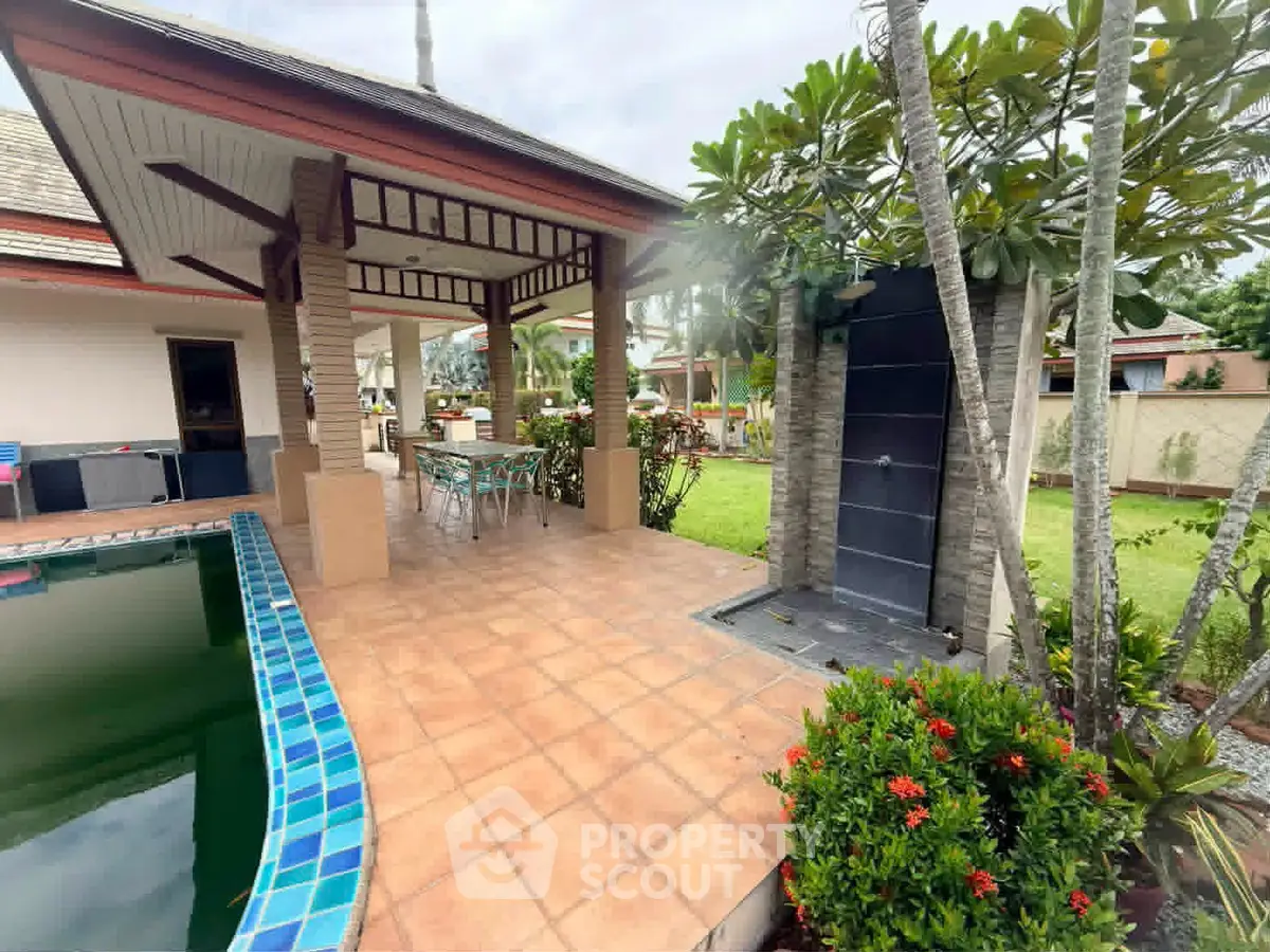 Luxurious tropical villa with poolside patio and lush garden, perfect for relaxation and entertaining.