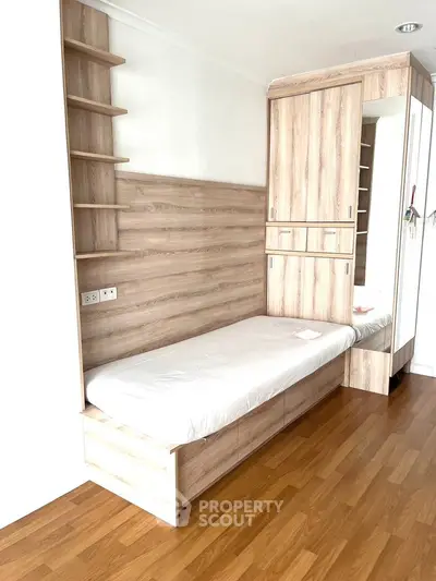 Compact bedroom with built-in wooden storage and single bed