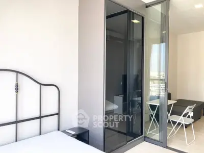 Modern bedroom with glass partition and balcony access in a stylish apartment