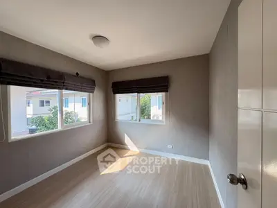 Bright empty room with large windows and wooden flooring in modern home