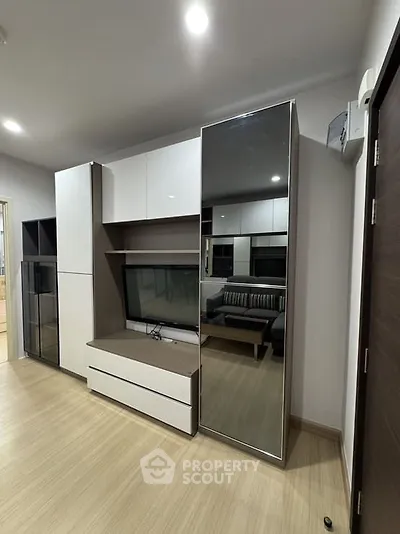 Modern living room with sleek furniture and built-in storage solutions.