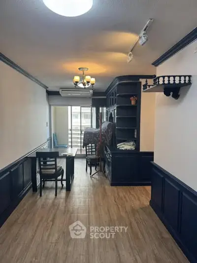 Charming dining area with wooden flooring and elegant dark wood accents.