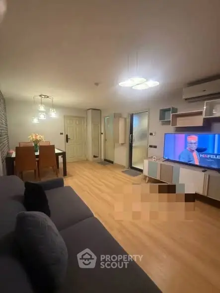 Modern living room with stylish decor and open dining area, featuring a cozy ambiance and contemporary furniture.