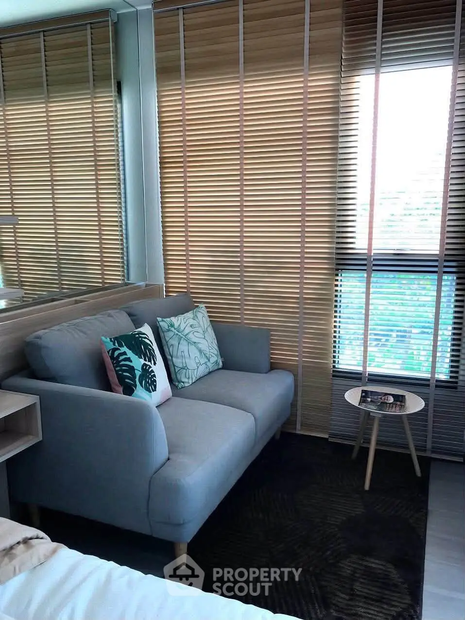 Cozy living room with modern sofa and stylish blinds in a bright apartment.
