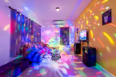 Vibrant living room with colorful disco lights, cozy seating, and modern entertainment setup.
