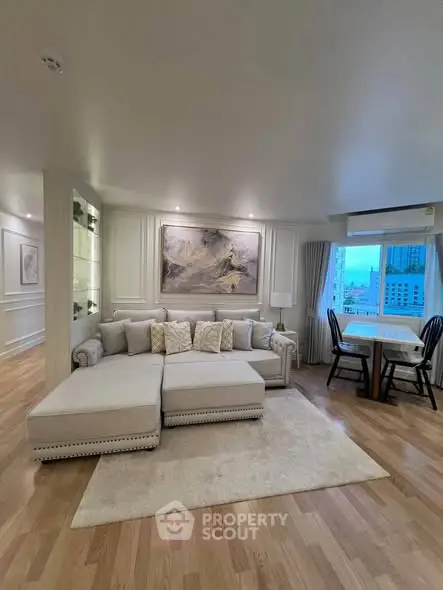 Luxurious living room with elegant decor and city view, featuring plush sectional sofa and dining area.