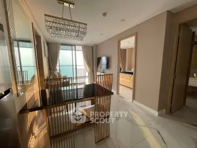 Luxurious apartment dining area with elegant chandelier and ocean view balcony.