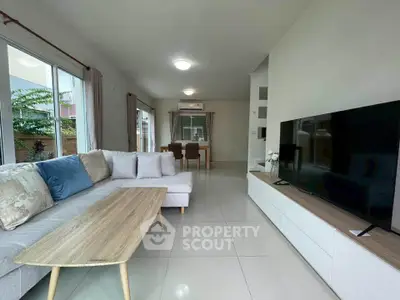 Spacious modern living room with large TV and comfortable sofa, perfect for relaxation.