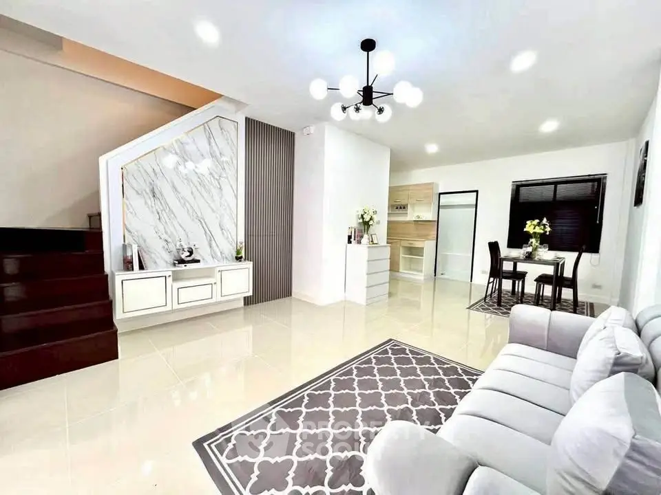 Modern living room with elegant staircase and dining area