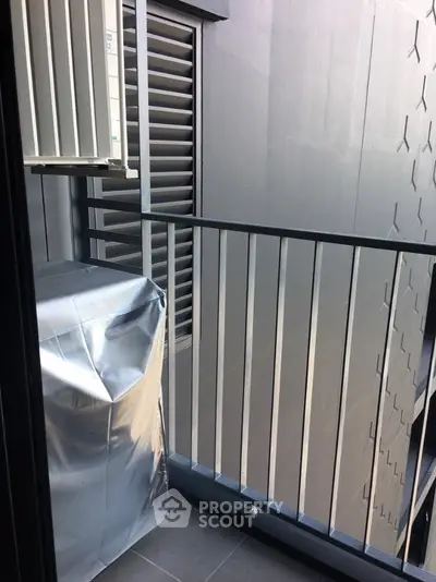 Modern apartment balcony with sleek metal railing and urban view.