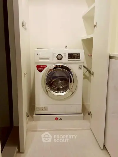 Modern laundry area with built-in LG washing machine in sleek cabinet.