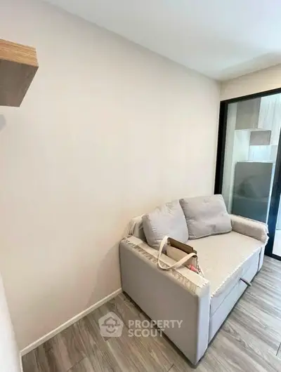 Cozy living room with modern sofa and wooden flooring, perfect for relaxation.
