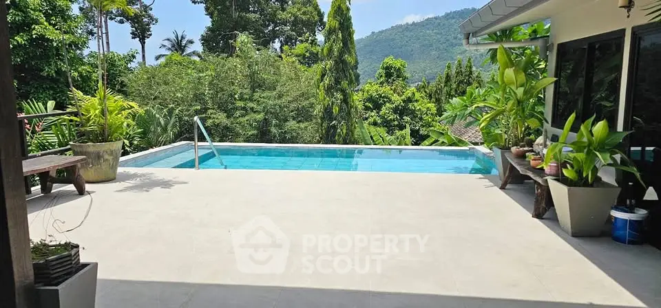 Stunning poolside view with lush greenery and mountain backdrop, perfect for relaxation and luxury living.