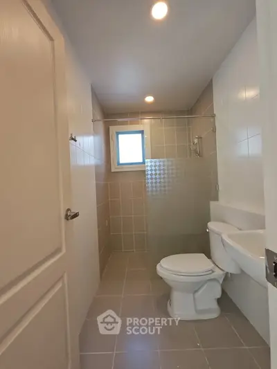 Modern bathroom with tiled walls and glass partition