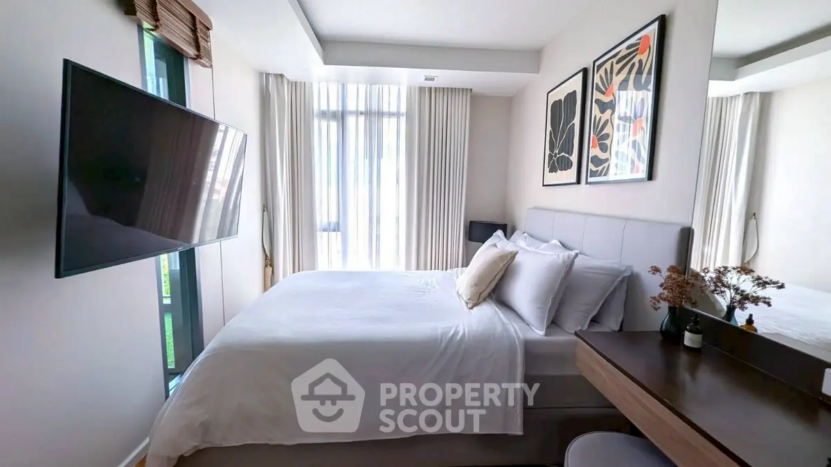 Modern bedroom with stylish decor and large window for natural light.