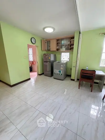 Spacious kitchen with green walls, modern appliances, and natural light.
