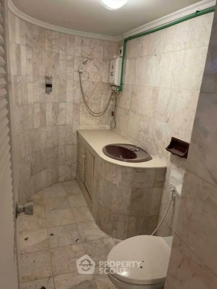 Compact bathroom with marble tiles and modern fixtures