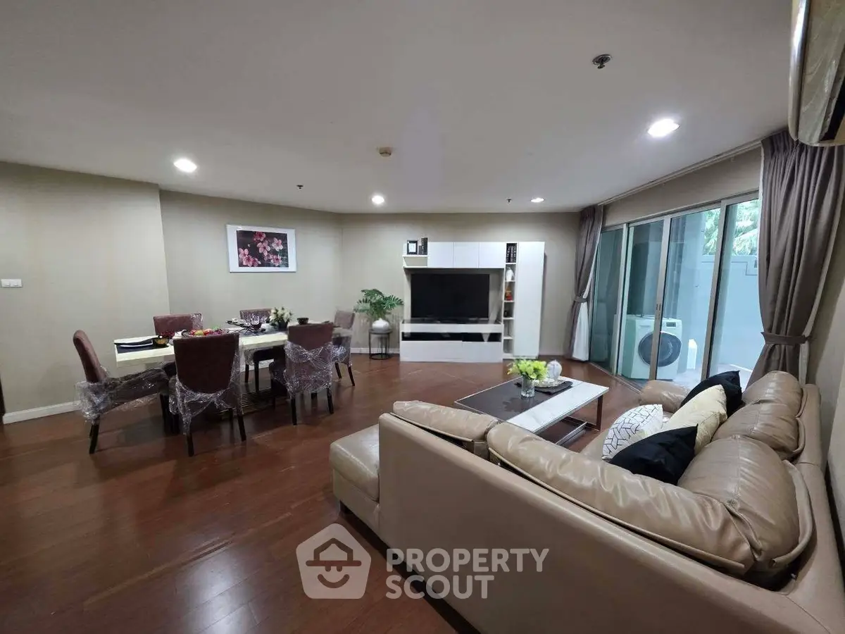 Spacious living room with modern decor and large windows in a luxury apartment.