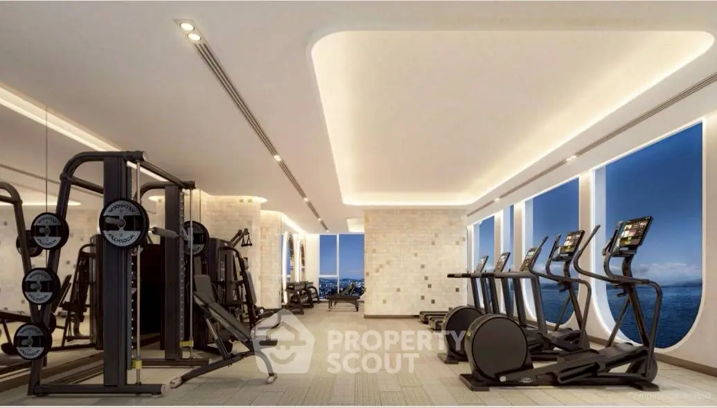 Luxurious gym with modern equipment and ocean view windows.
