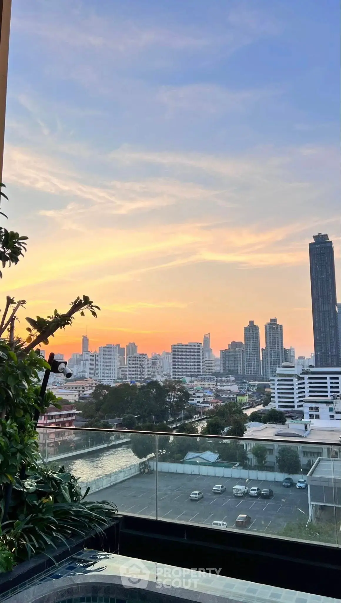 Stunning cityscape view from a high-rise balcony at sunset, perfect for urban living.
