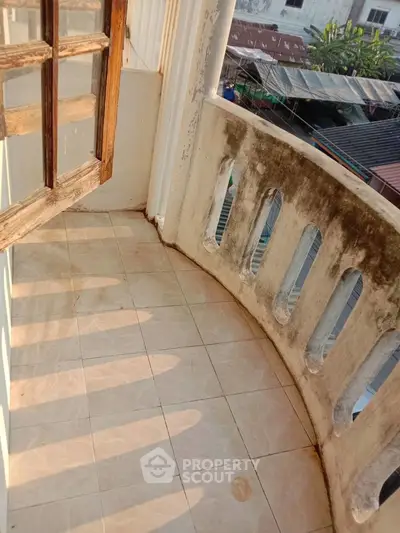 Charming balcony with rustic wooden door and city view, perfect for relaxation.