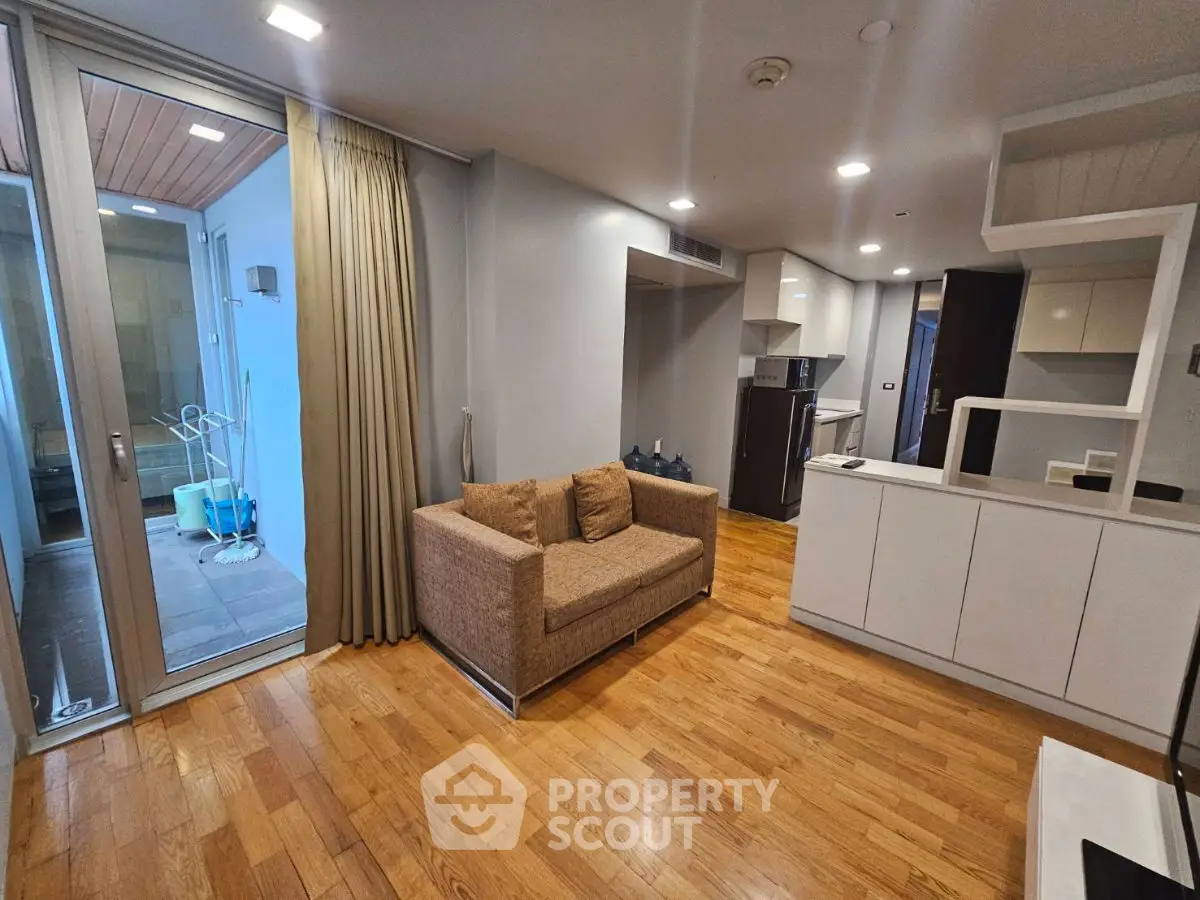 Modern living room with hardwood floors and open kitchen layout