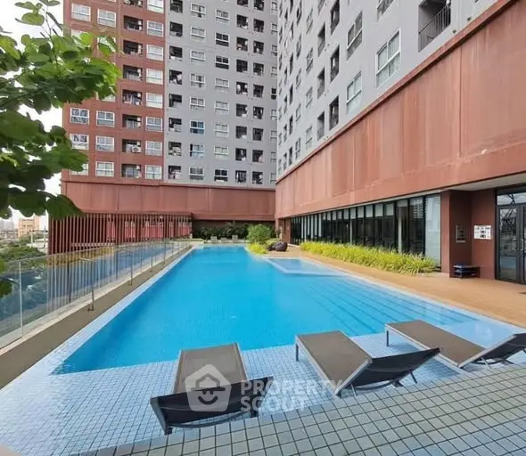 Modern apartment building with a luxurious outdoor pool and sun loungers.