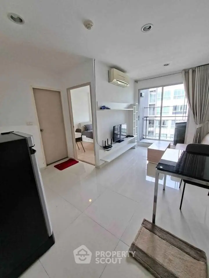 Modern living room with sleek design, large windows, and balcony access in a contemporary apartment.
