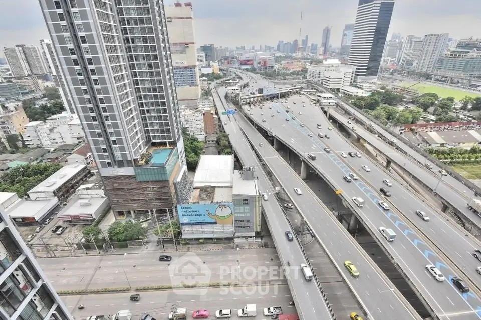 Stunning cityscape view from high-rise building overlooking busy highway and urban skyline.