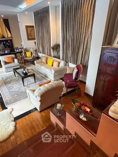 Elegant living room with plush seating, wooden flooring, and stylish decor accents.