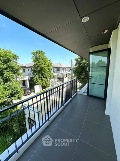 Spacious balcony with modern railing and serene neighborhood view