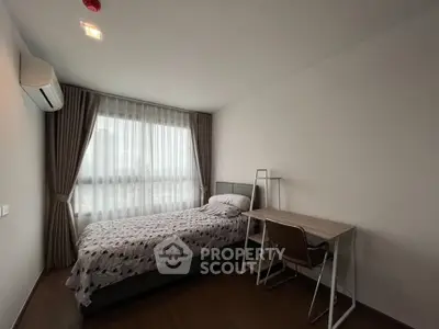 Cozy bedroom with modern furnishings and natural light in a stylish apartment.