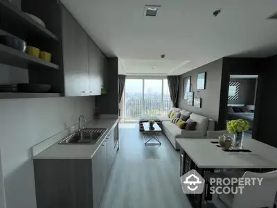 Modern open-plan living room with kitchen and city view balcony