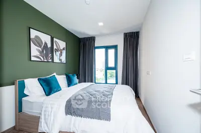 Modern bedroom with stylish decor and large window offering natural light.