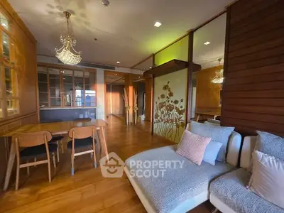 Luxurious open-plan living room with elegant wooden accents and modern chandelier.