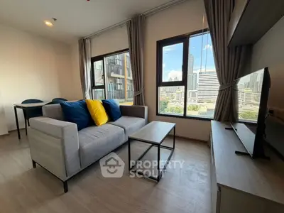 Modern living room with city view, featuring stylish sofa and TV setup, perfect for urban living.
