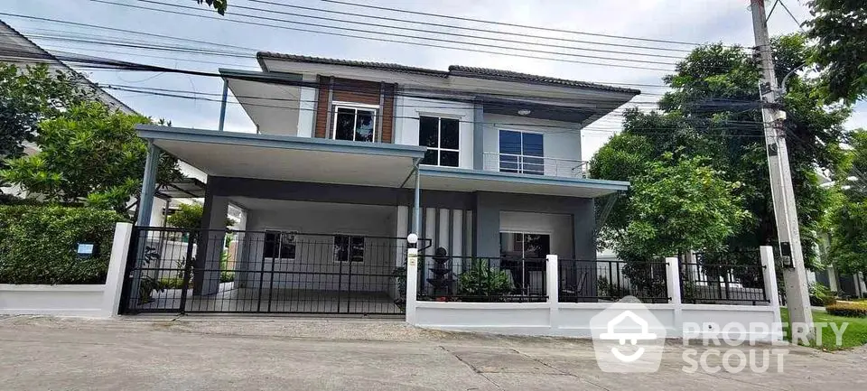 Modern two-story house with spacious driveway and lush greenery