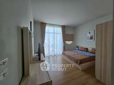 Spacious modern bedroom with large window and stylish decor