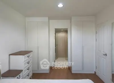 Spacious bedroom with built-in wardrobes and elegant wooden flooring