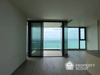 Stunning ocean view from modern apartment with spacious balcony and sleek flooring.