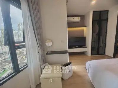 Modern bedroom with city view, featuring sleek design and natural light.