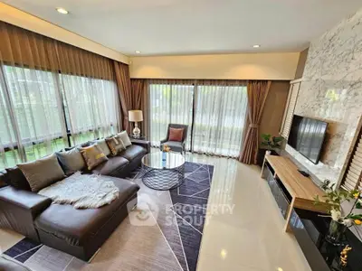 Luxurious living room with large windows, modern decor, and comfortable seating in a stylish home.