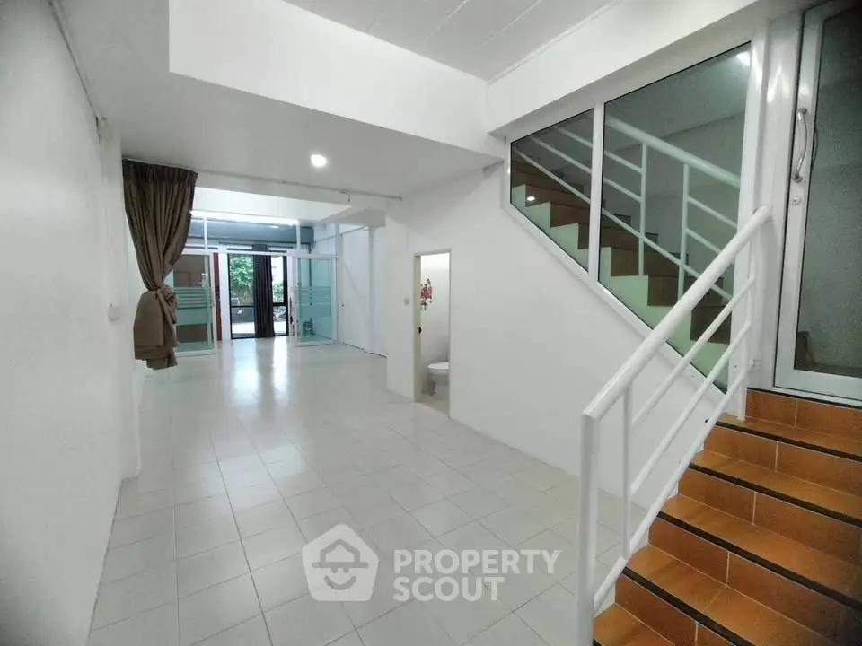 Spacious open-plan interior with staircase and large windows