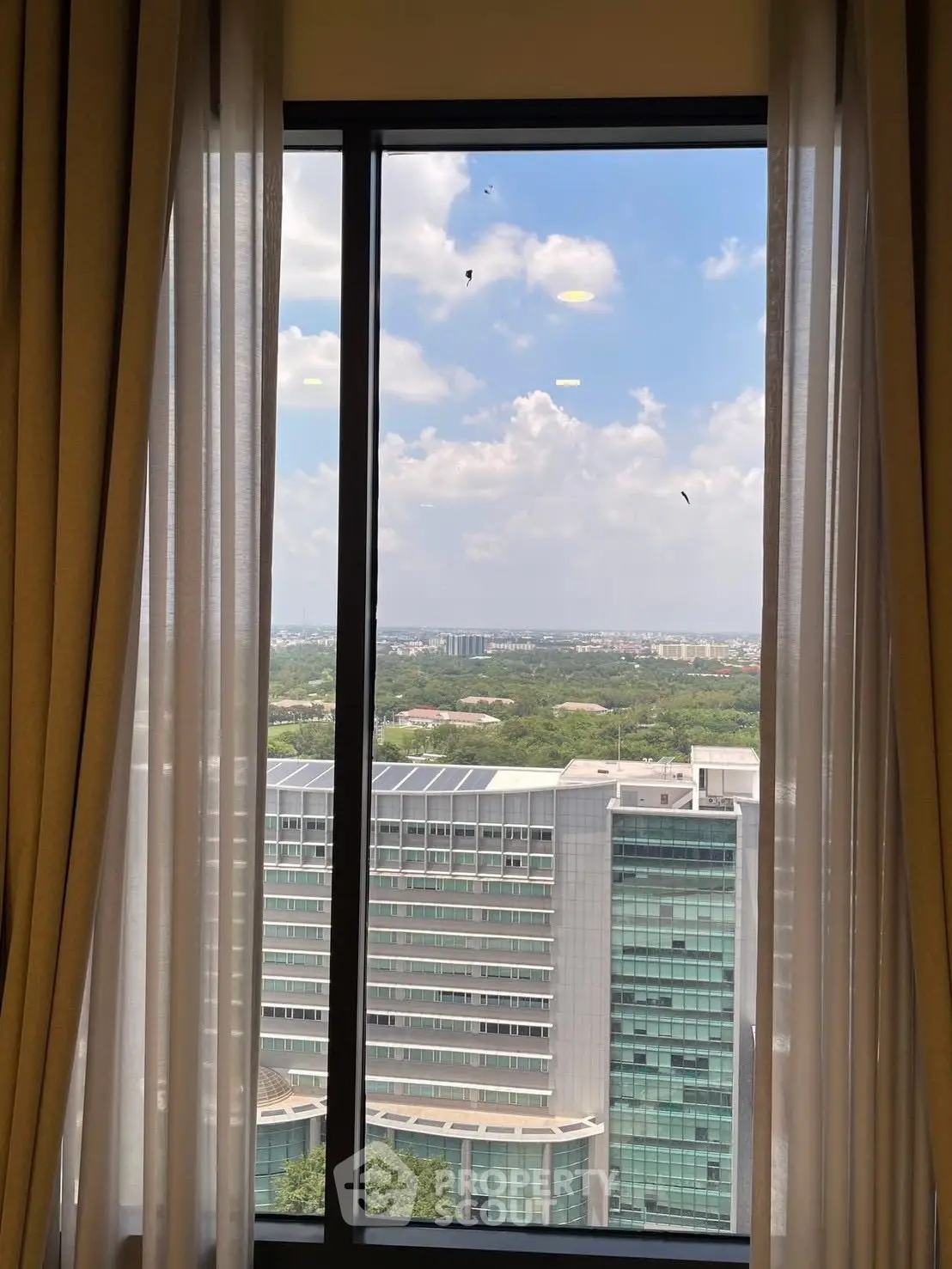 Stunning cityscape view from a high-rise apartment window, showcasing urban living at its finest.