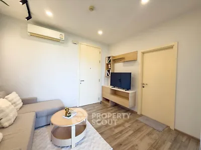 Modern living room with cozy sofa, TV, and stylish decor in a bright apartment.