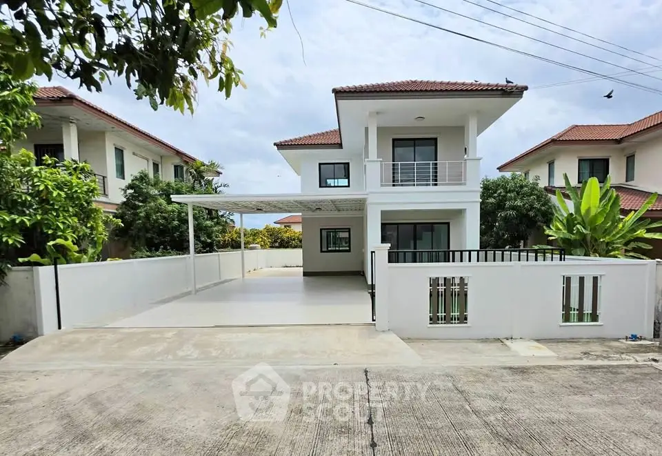 Charming two-story house with spacious driveway and lush greenery in a serene neighborhood.