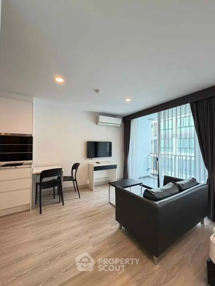 Modern living room with sleek furniture and large windows in a stylish apartment.