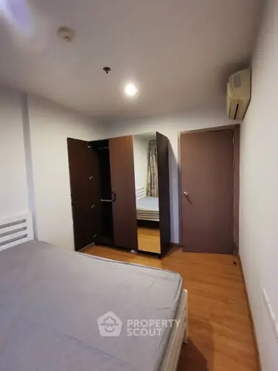 Cozy bedroom with wooden flooring and modern wardrobe