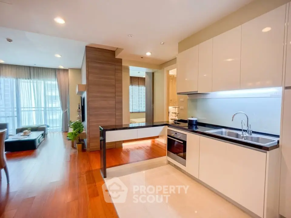 Modern open-layout kitchen with sleek cabinetry and integrated appliances in a stylish apartment.